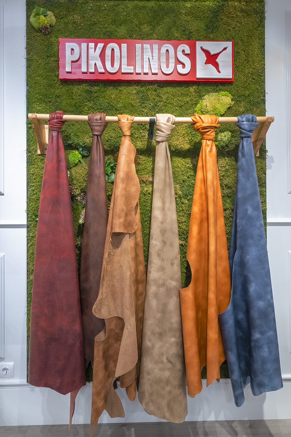 Image of skins hanging over a vertical garden in the Pikolinos store.